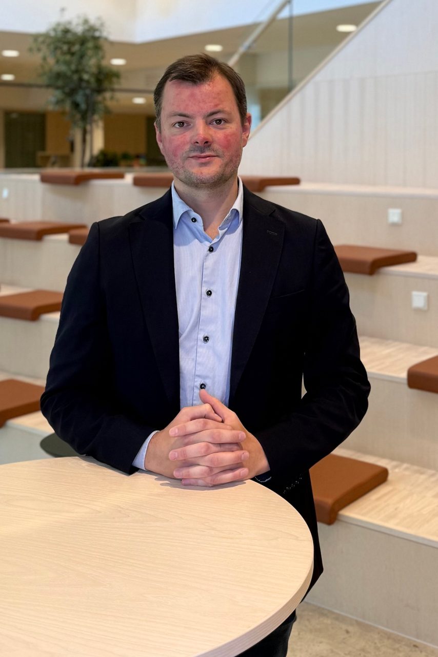 Man tittar in i kameran och ler