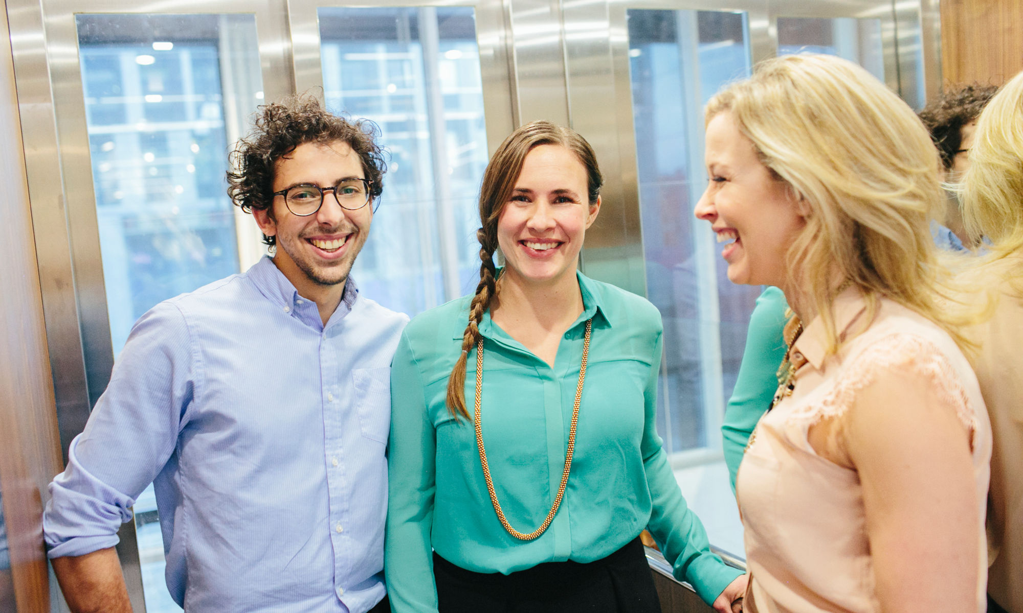 Tre glada personer i en hiss