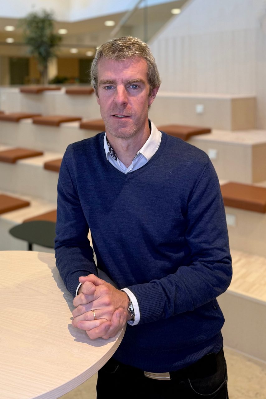 Man tittar in i kameran och ler