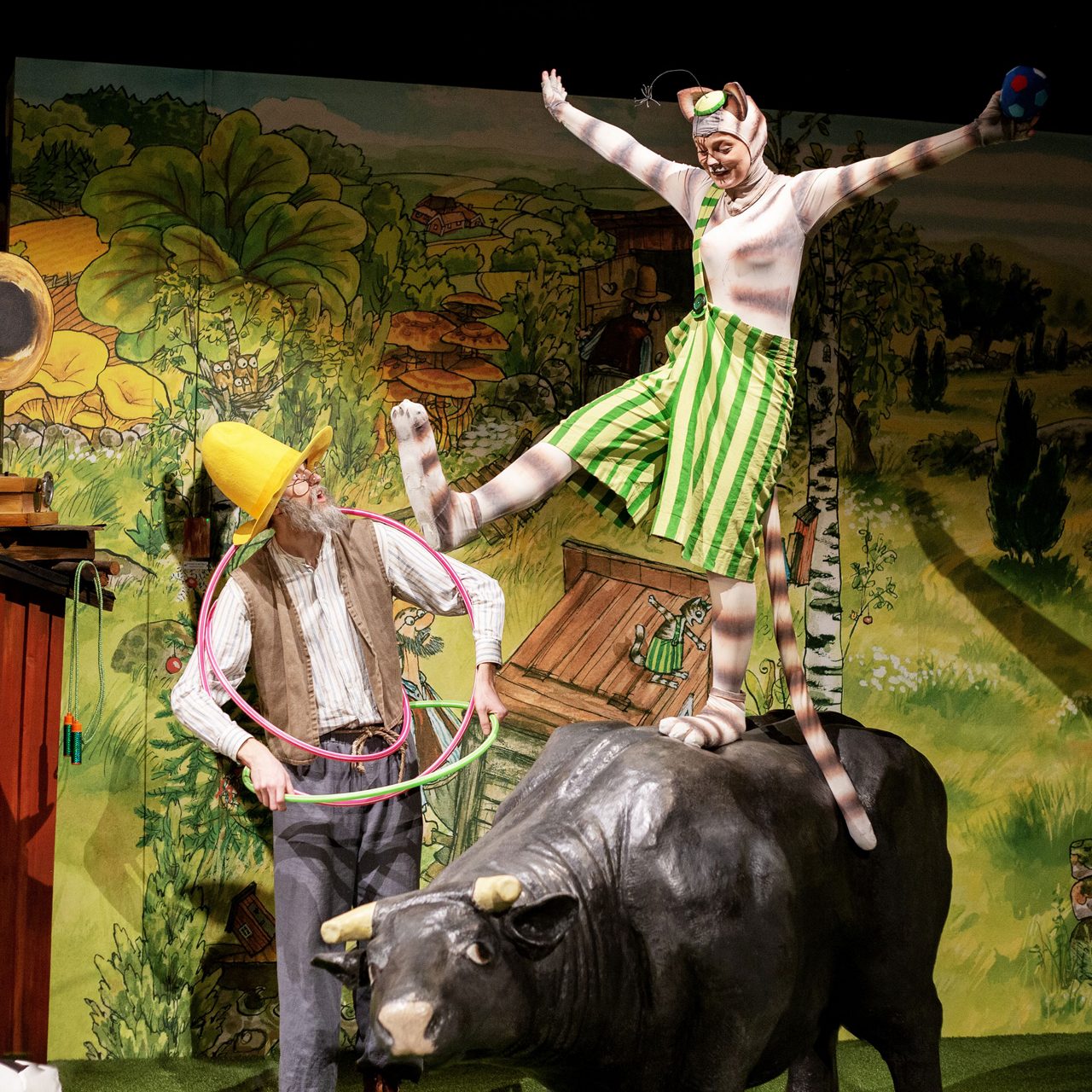 Pettson looking at his cat Findus dancing on a cow.