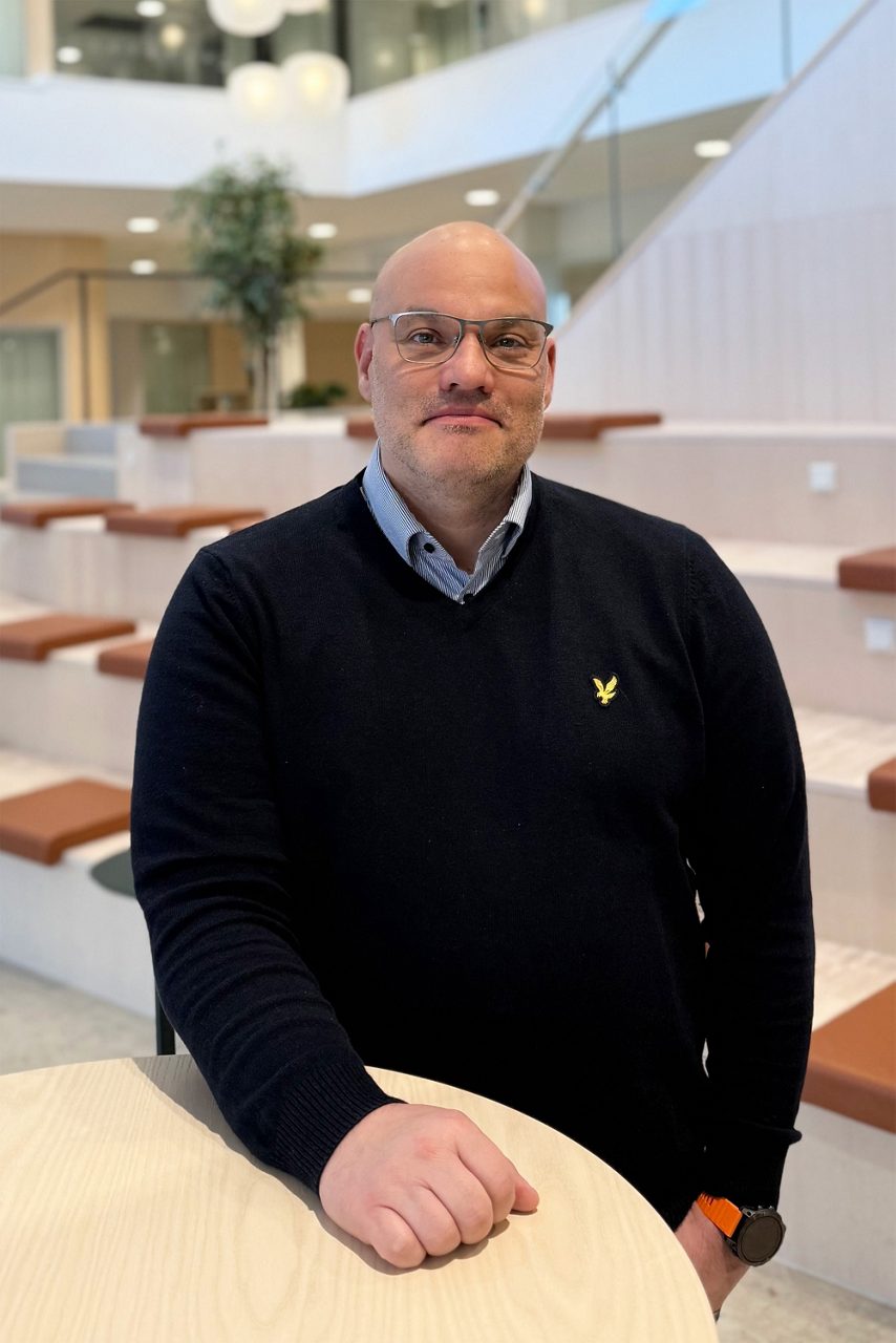 Man tittar in i kameran och ler