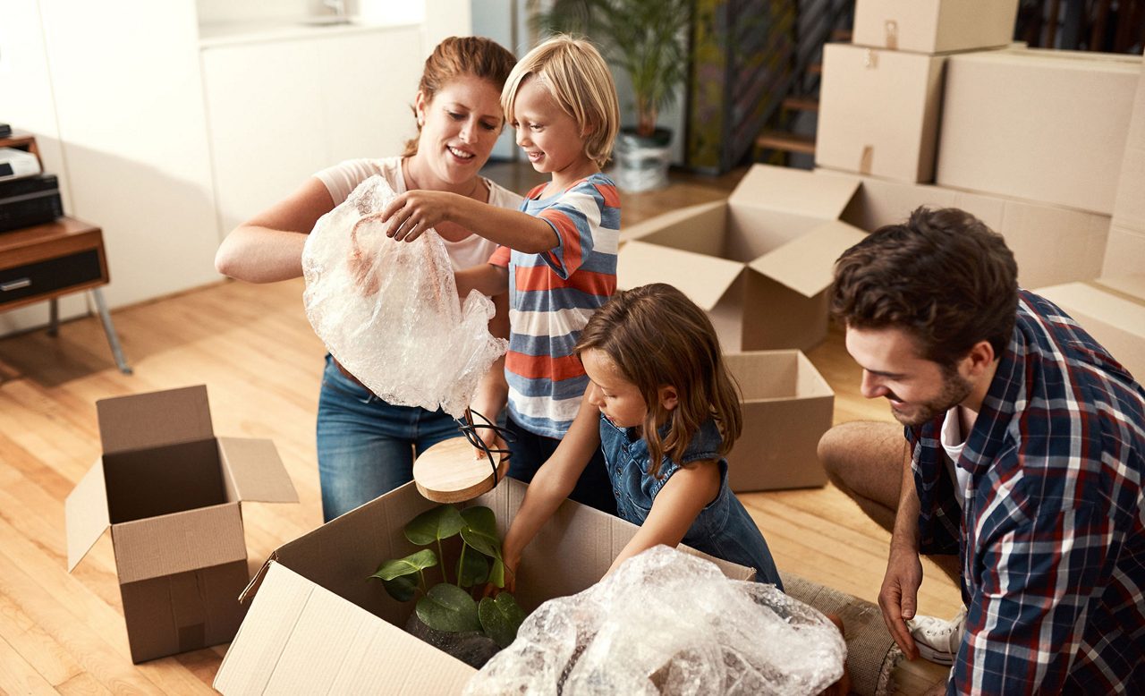 Familj  packar upp flyttlådor i sin lägenhet