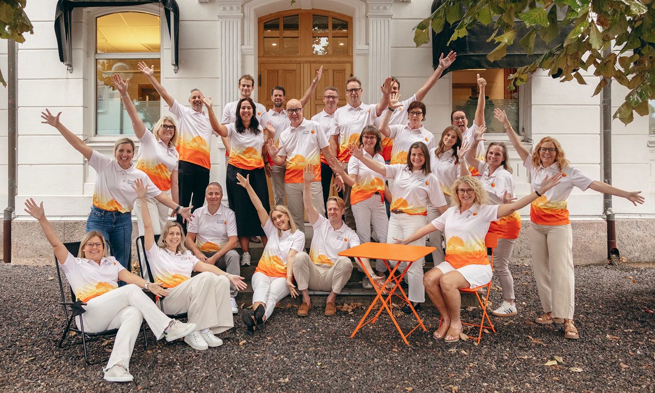 Många personer som är glada och firar med partyhattar, skyltar och coola solglasögon