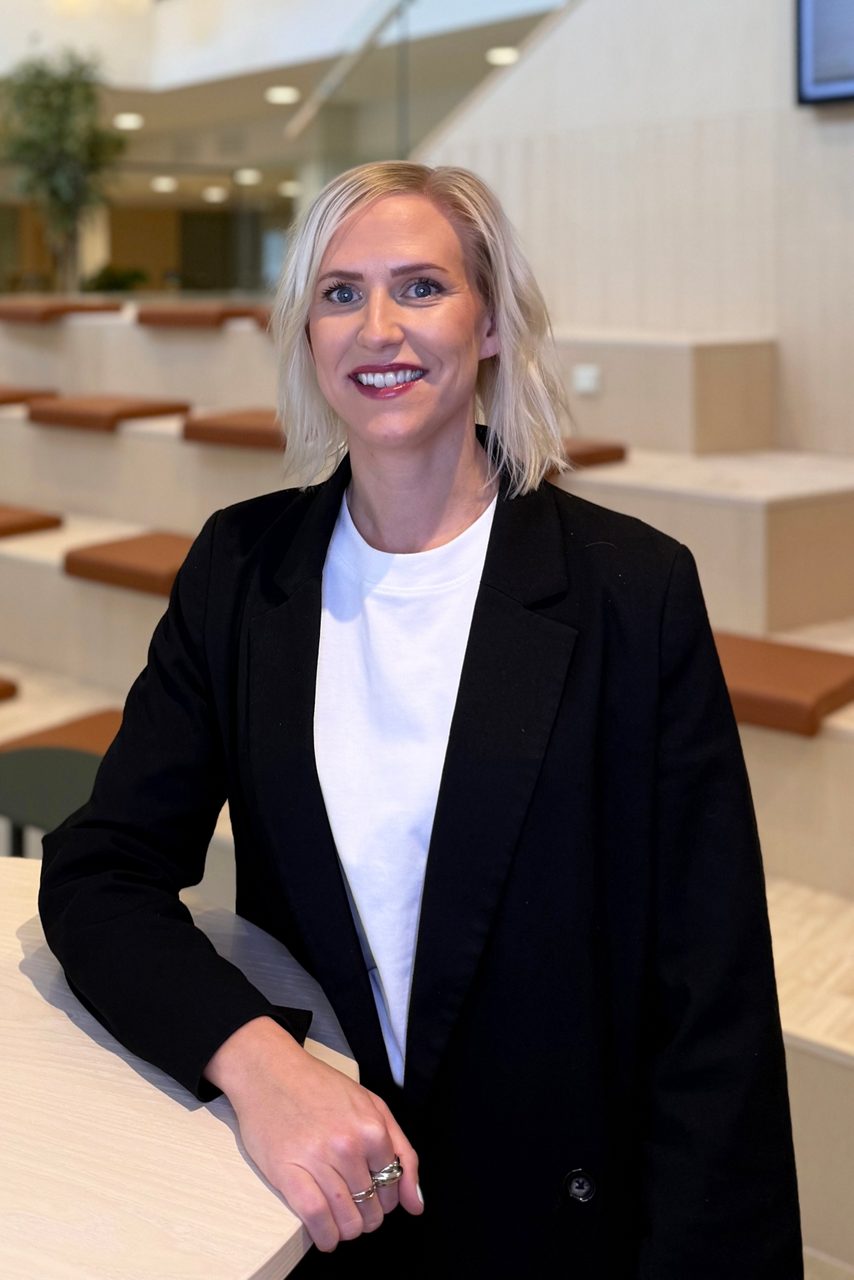 Kvinna tittar in i kameran och ler