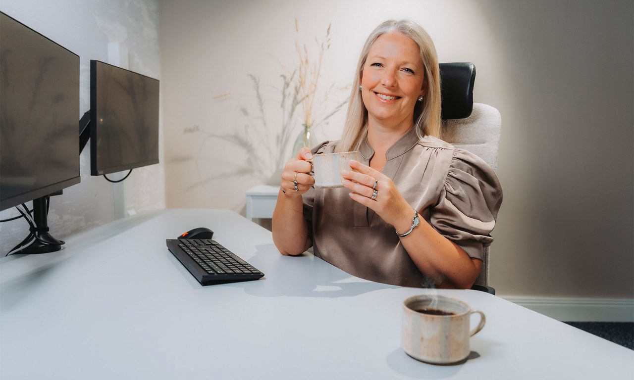 En rådgivare håller en kopp kaffe i ett rådgivningsrum.