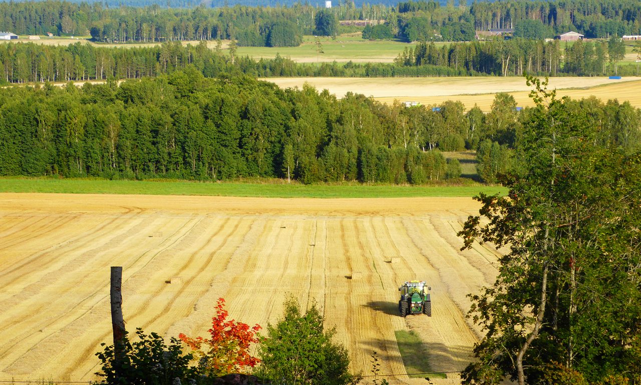 En traktor kör på en åker.