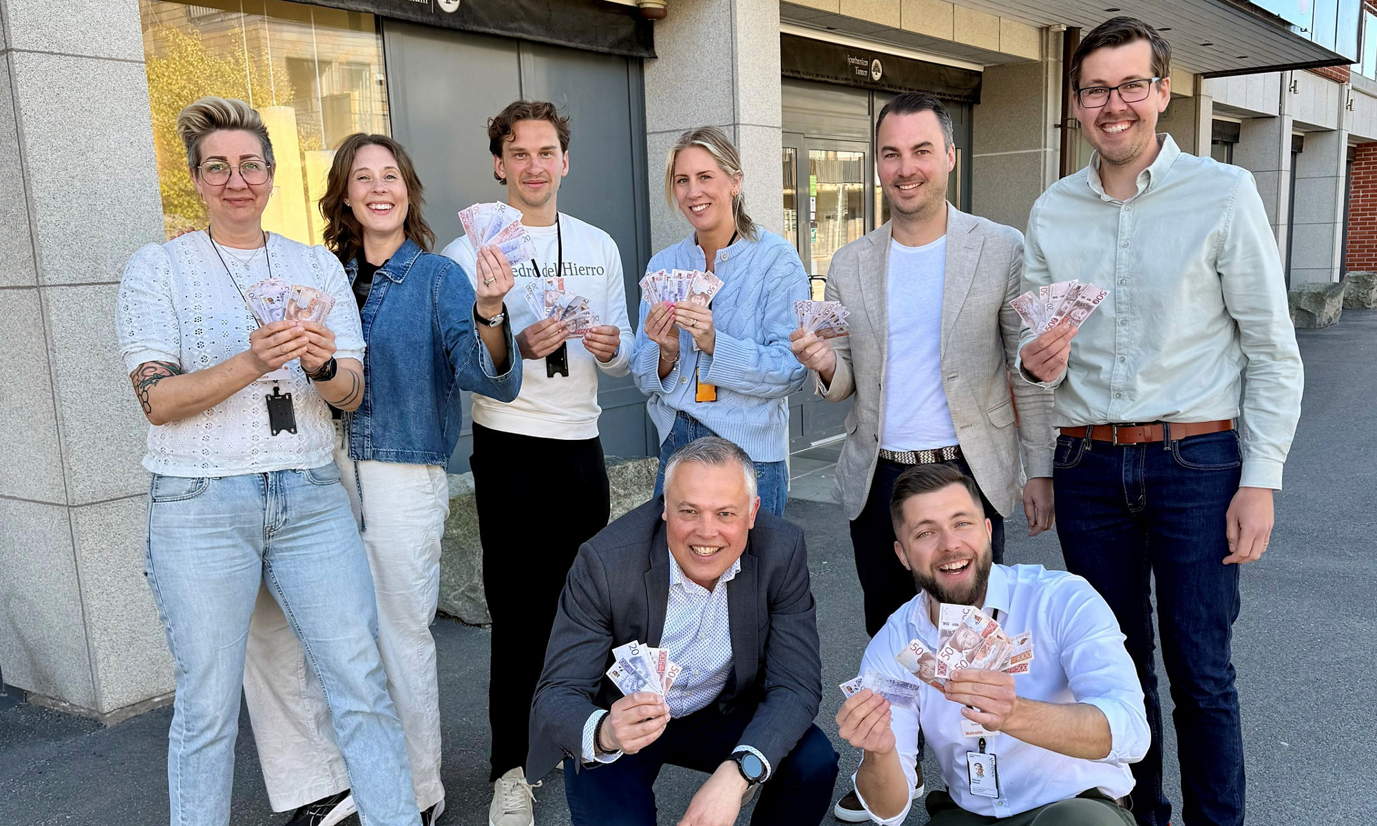 Gruppbild över några i personalen på Sparbanken Tanum som håller i kontanter