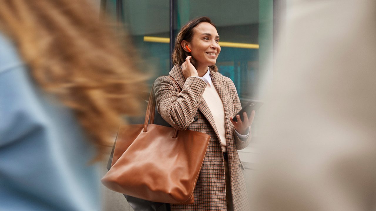 En kvinna går på stan och lyssnar på en ljudbok från Storytel