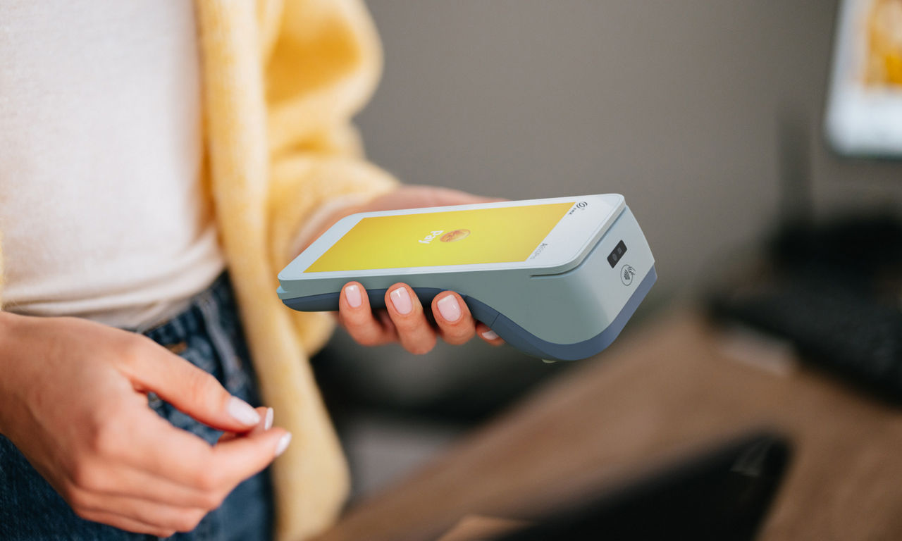 En betalterminal som ligger i en hand