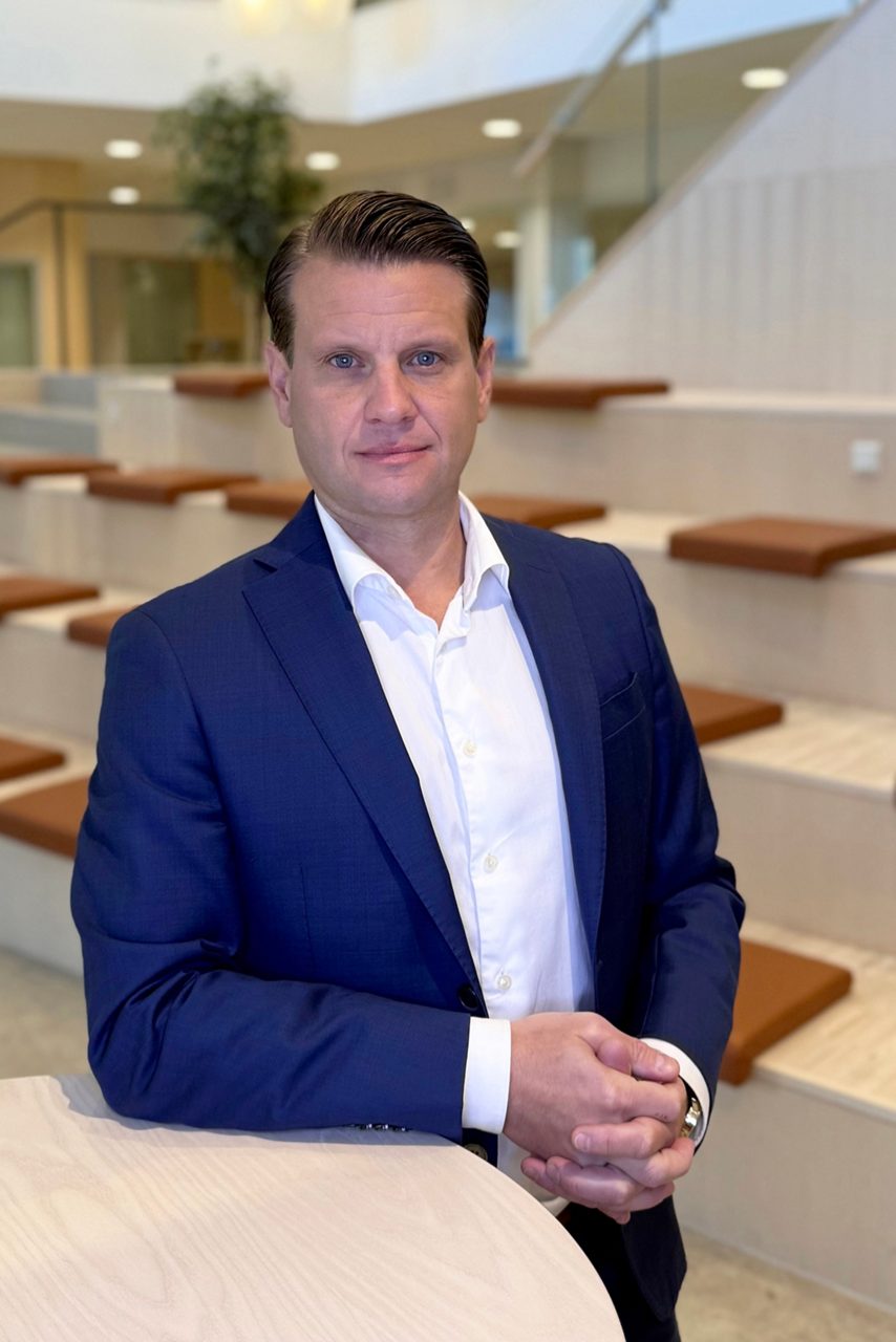 Man tittar in i kameran och ler