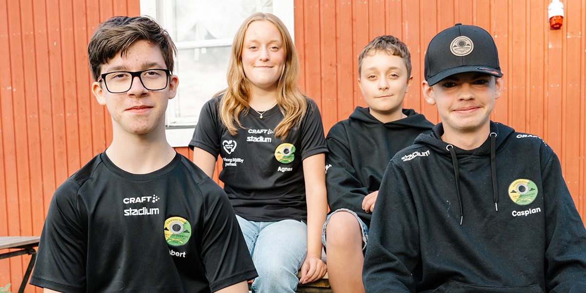 Fyra ungdommar, medlemmar i klubben, sitter utanför den gamla skyttehallen