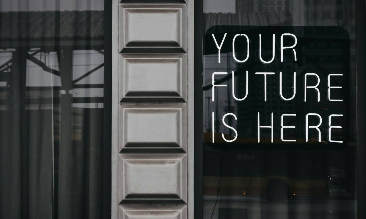 Reflektion i ett fönster med texten "Your future is here"