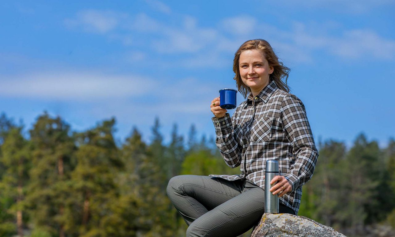 Kerstin sitter på en sten i skogen