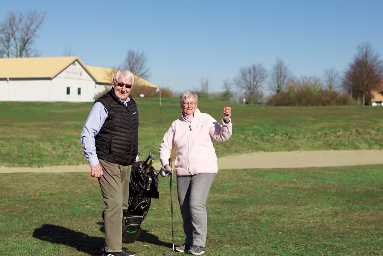 äldre par på golfbanan