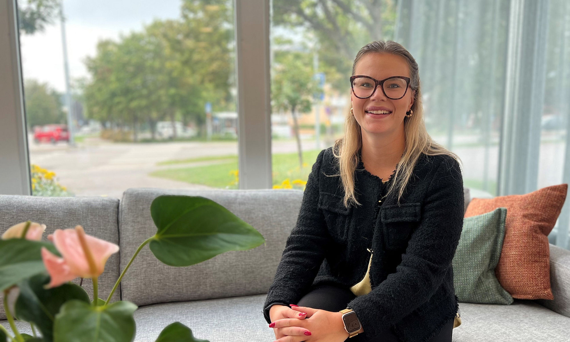 kvinna i svart kavaj ler mot kameran