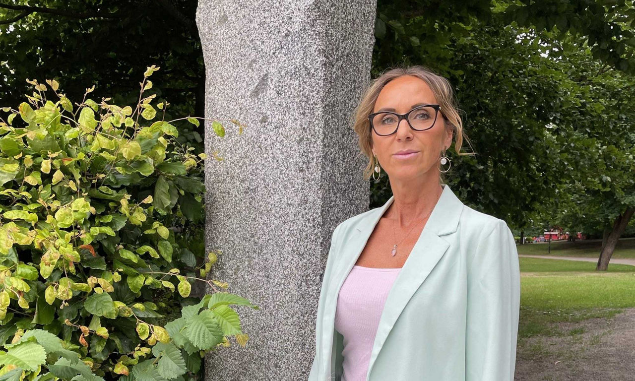 kvinna i turkos kavaj ståendes i en park