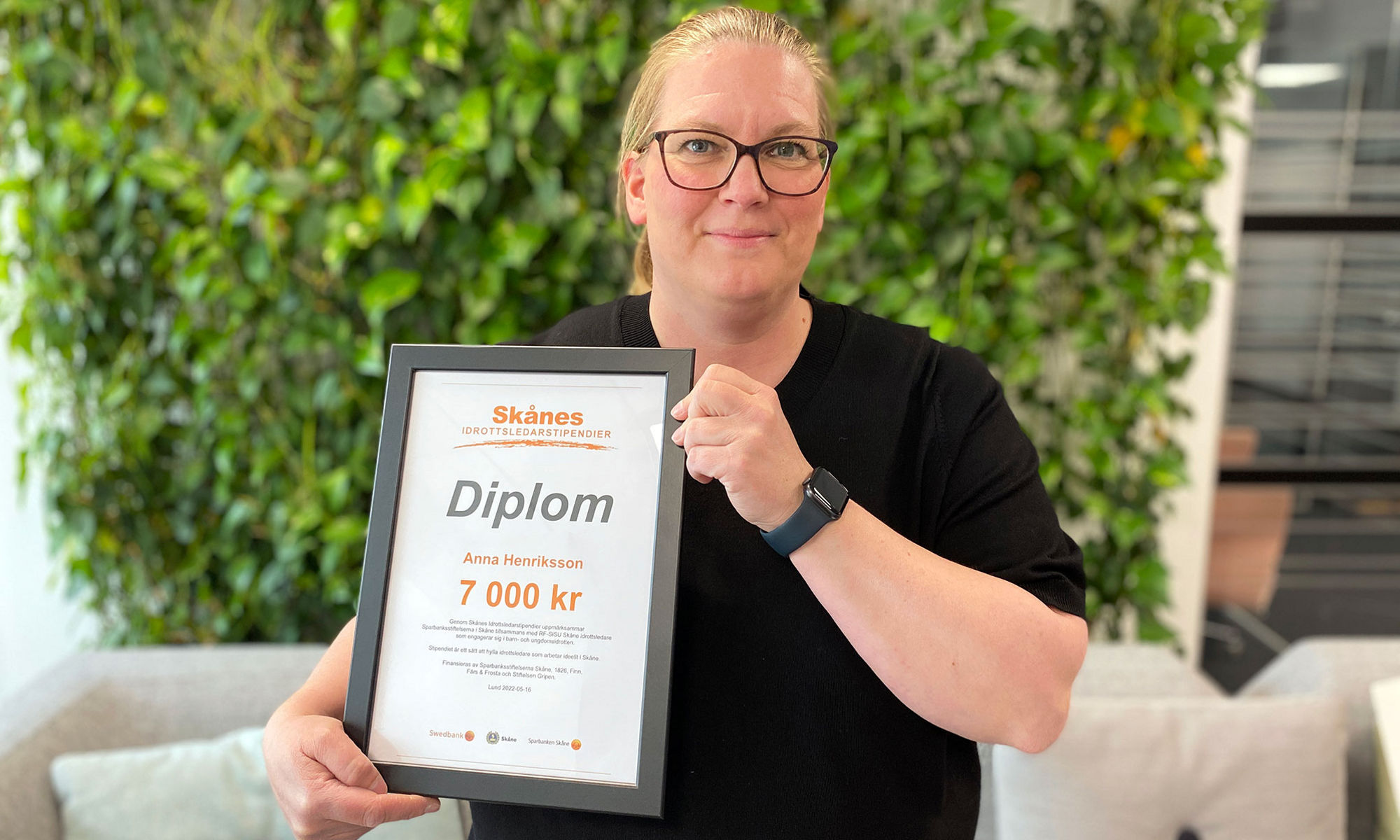 Anna Henriksson håller sitt idrottsledarstipendium i sina händer.