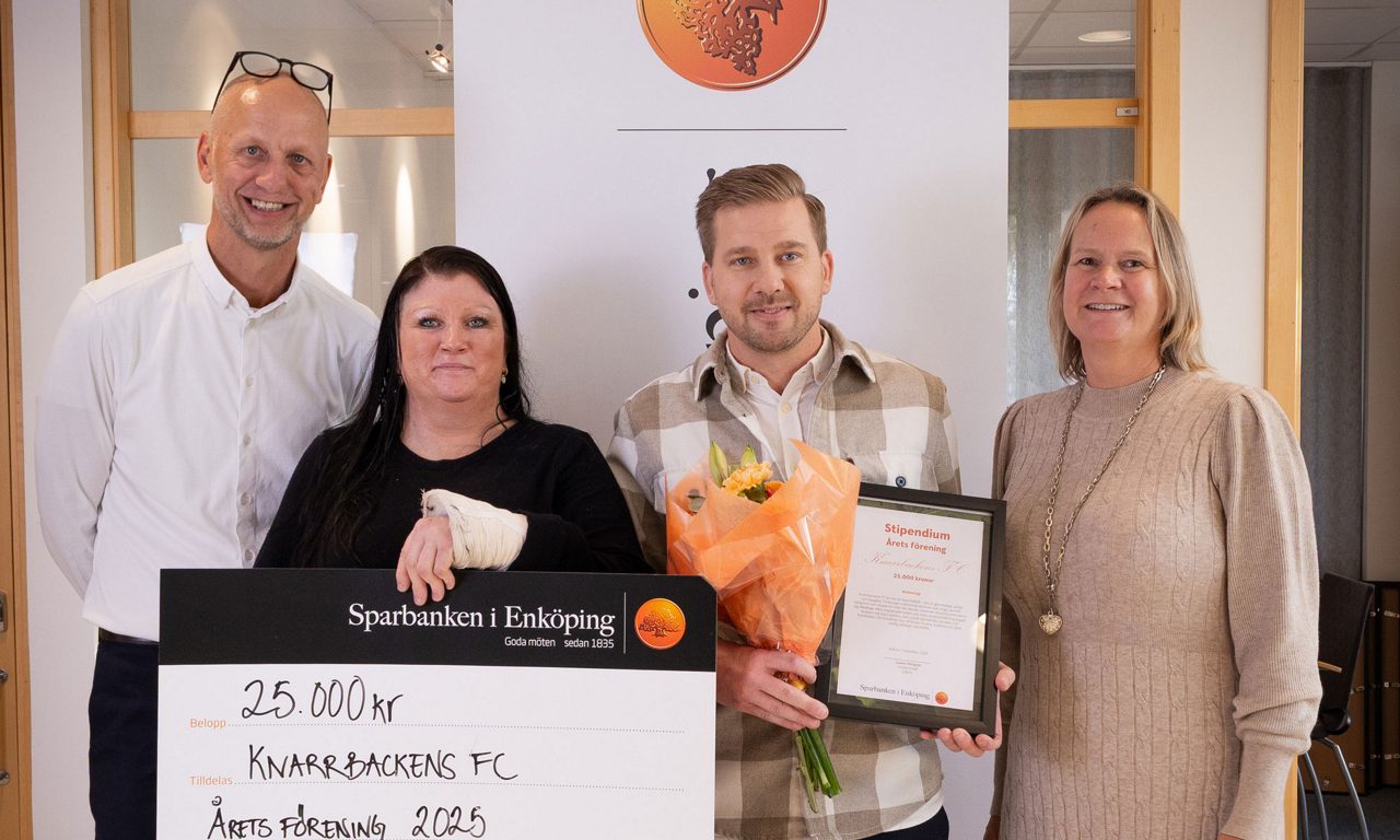 två män och två kvinnor hållandes check diplom och blombukett