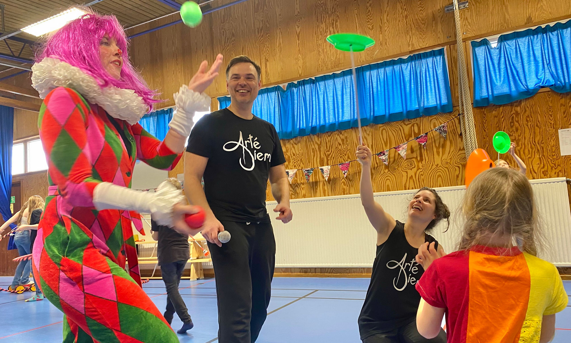 Cirkusartister gör cirkuskonster för elever i en skola.
