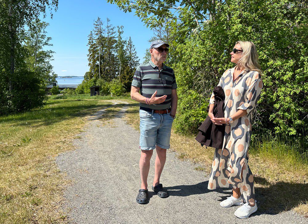En man och en kvinna står på en grusväg och pratar