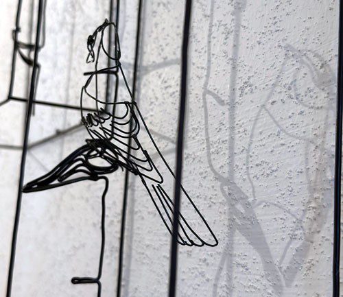 Skulptur av en fågel gjord av tjock ståltråd