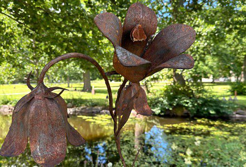Rostig metallskulptur föreställande blommor