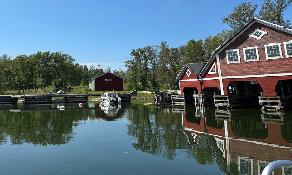 En liten hamn i naturen med ett rött hamnhus