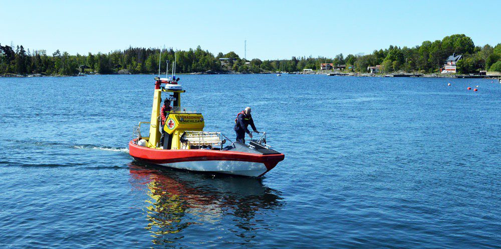 Räddningsbåt på en sjö med en person som styr och en som står i fören