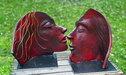 Två röda skulpturer av ansikten riktade mot varandra