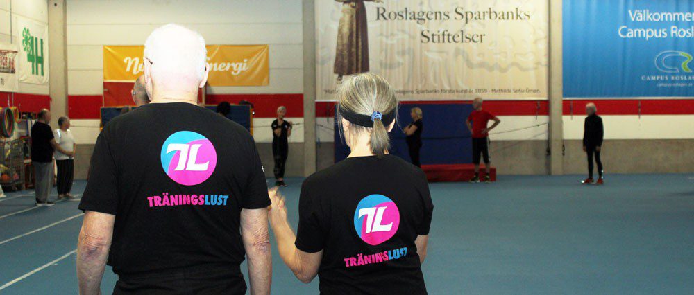 En man och en kvinna i en gymnastiksal med tröjor med texten "Träningslust"