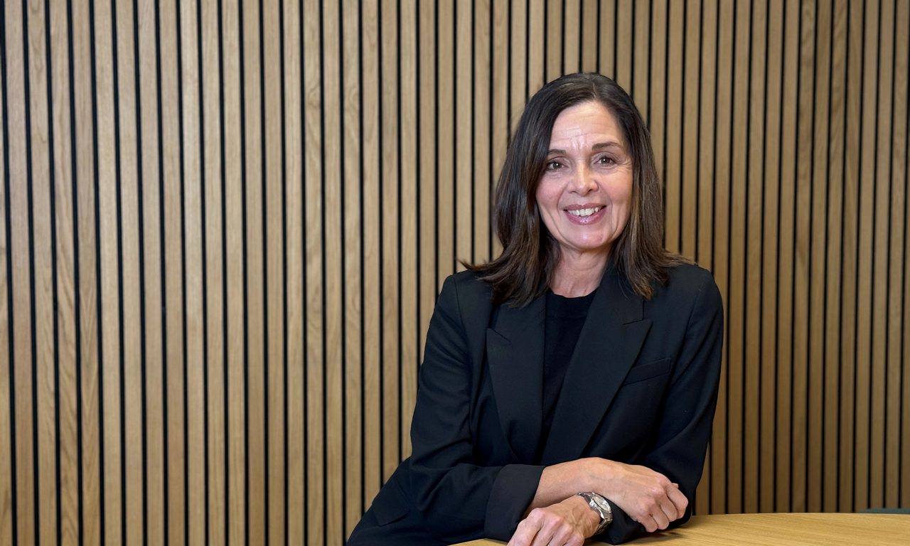 kvinna i svart kavaj ler mot kameran