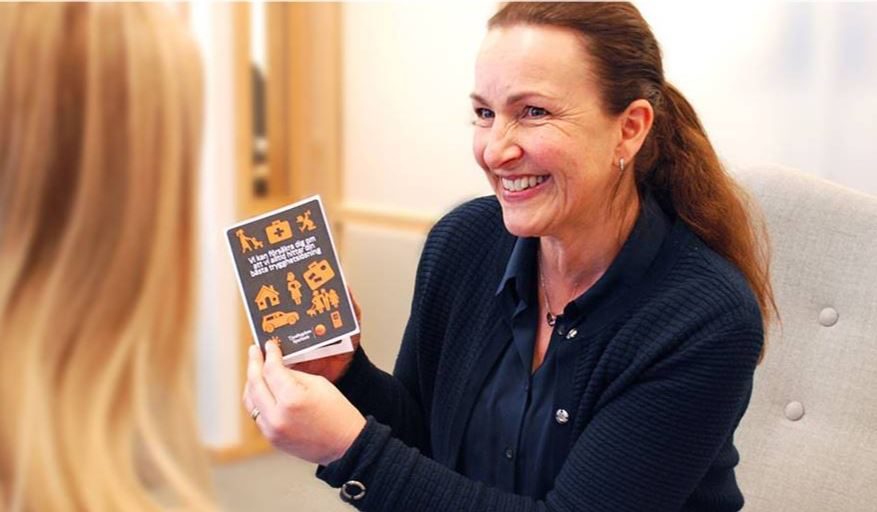 Private Banking rådgivare Karin Sjögren visar folder med försäkringsprodukter