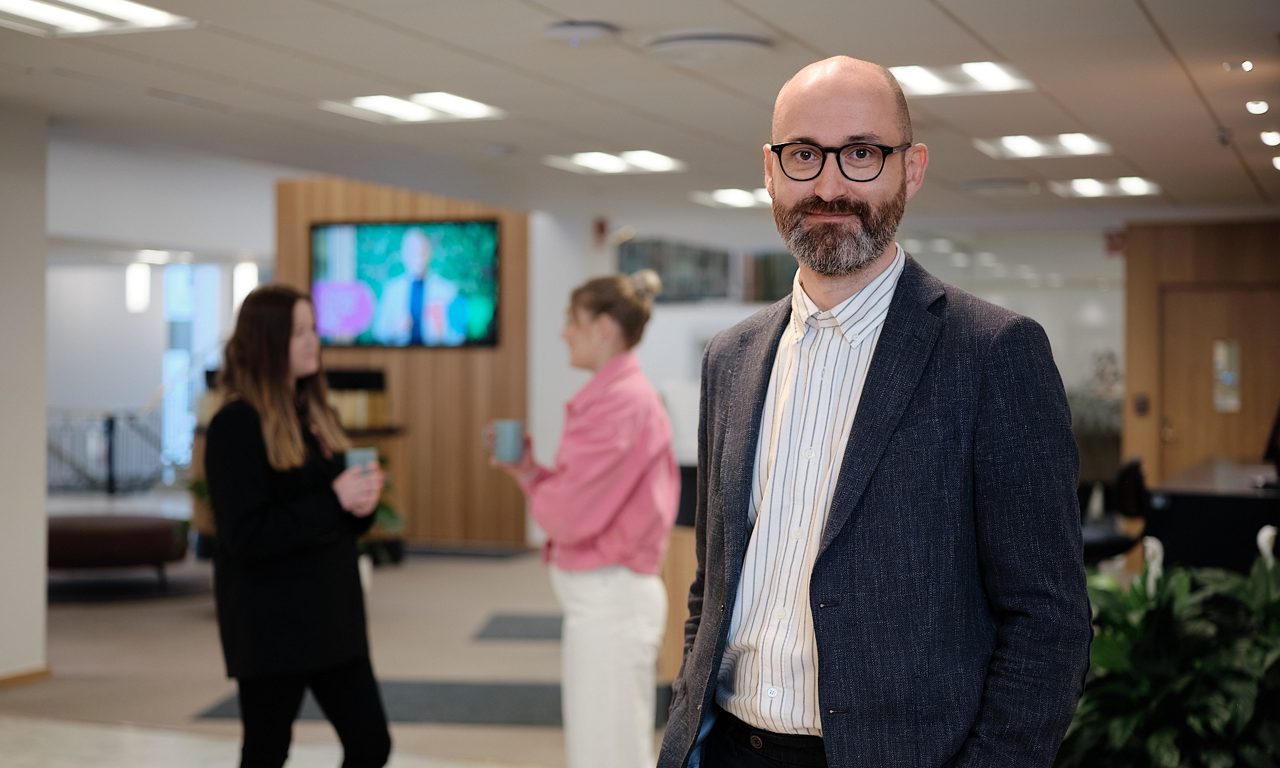 En man som står och tittar in i kameran