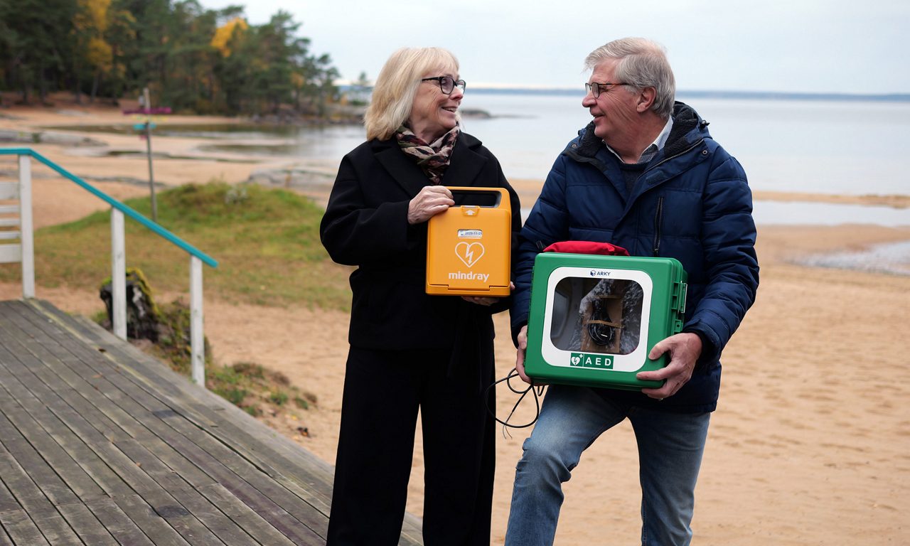 Man och kvinna som håller i hjärtstartare