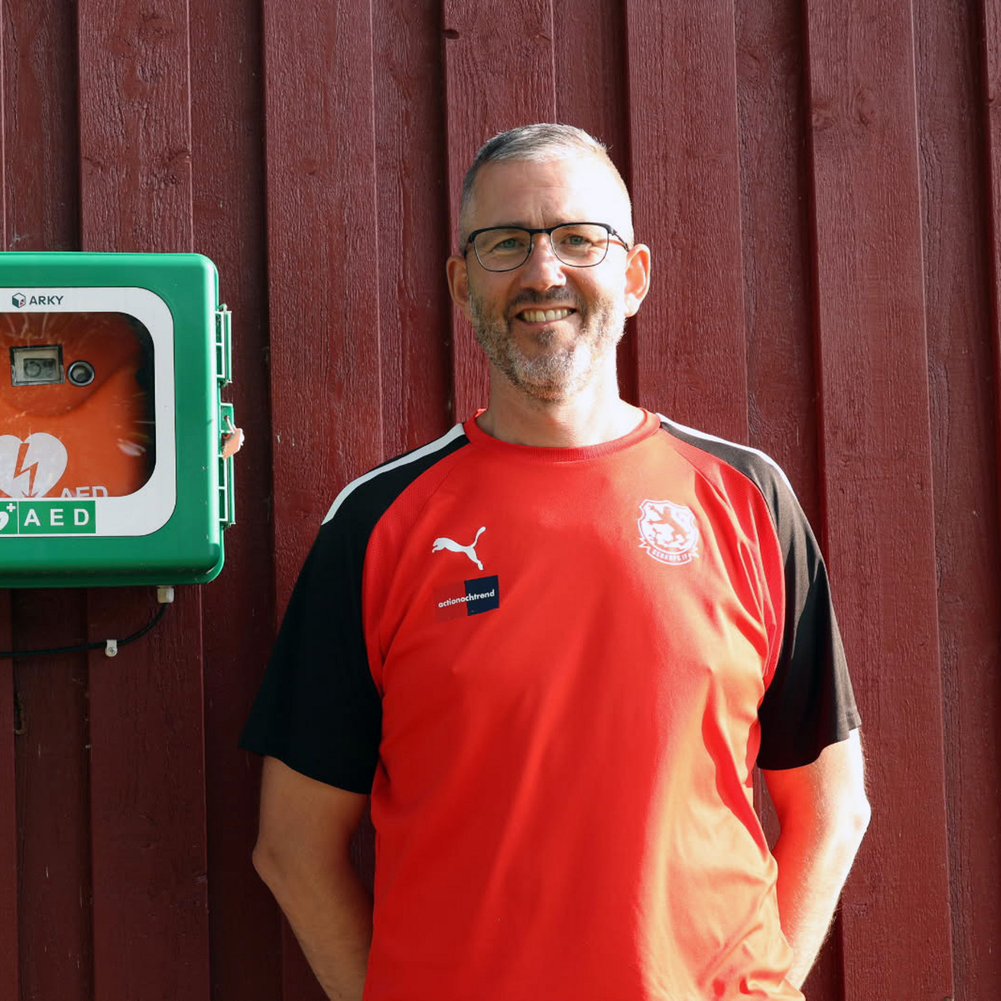 Man som står bredvid en hjärtstartare.