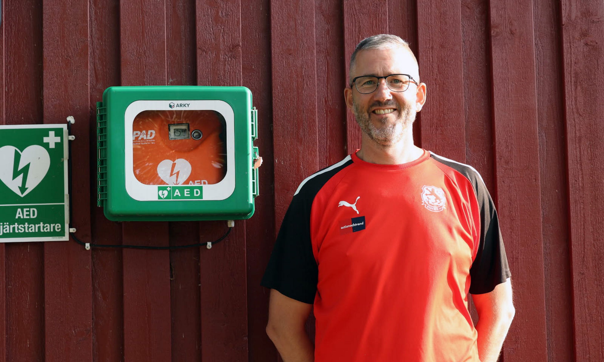 Man som står bredvid en hjärtstartare.