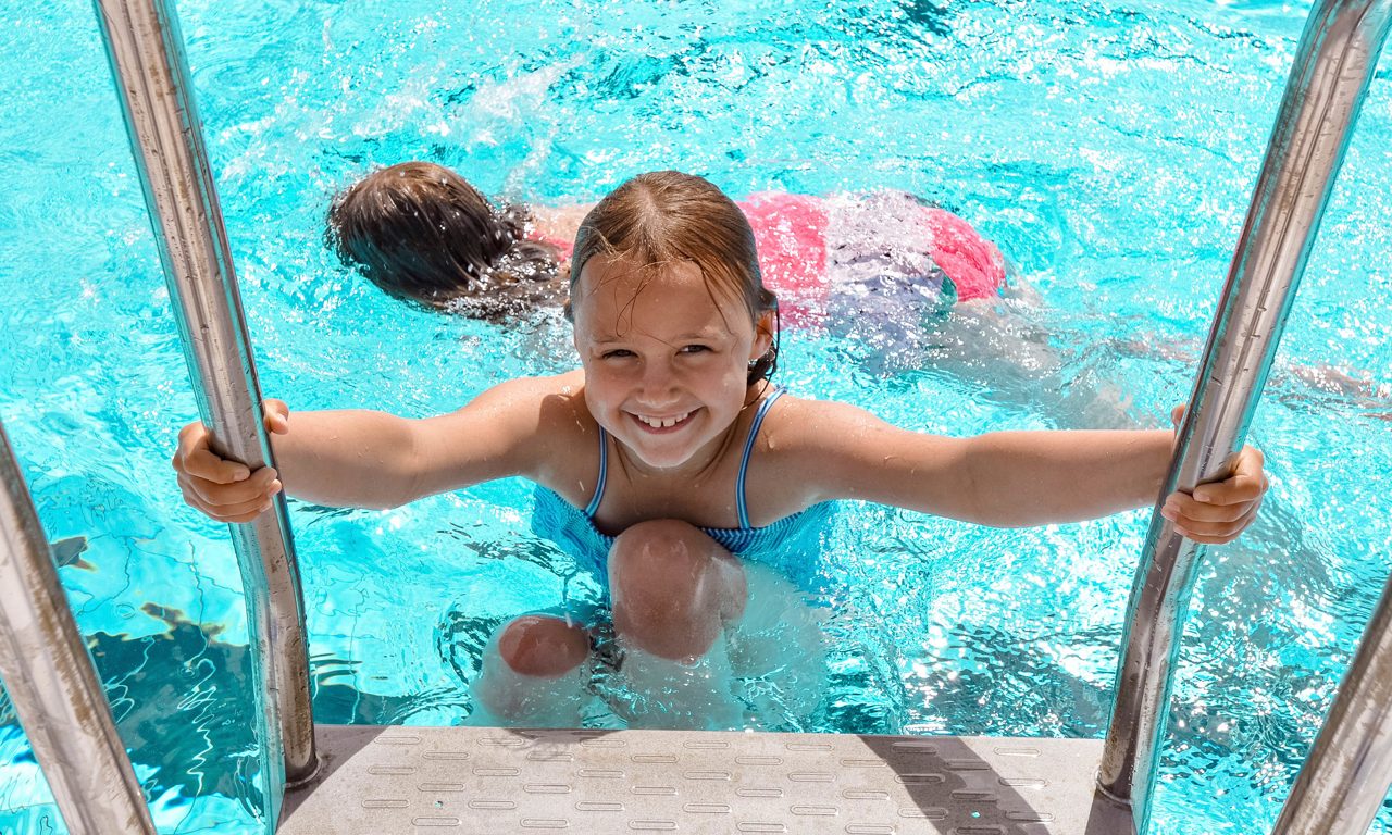 Barn som går ur simbassäng