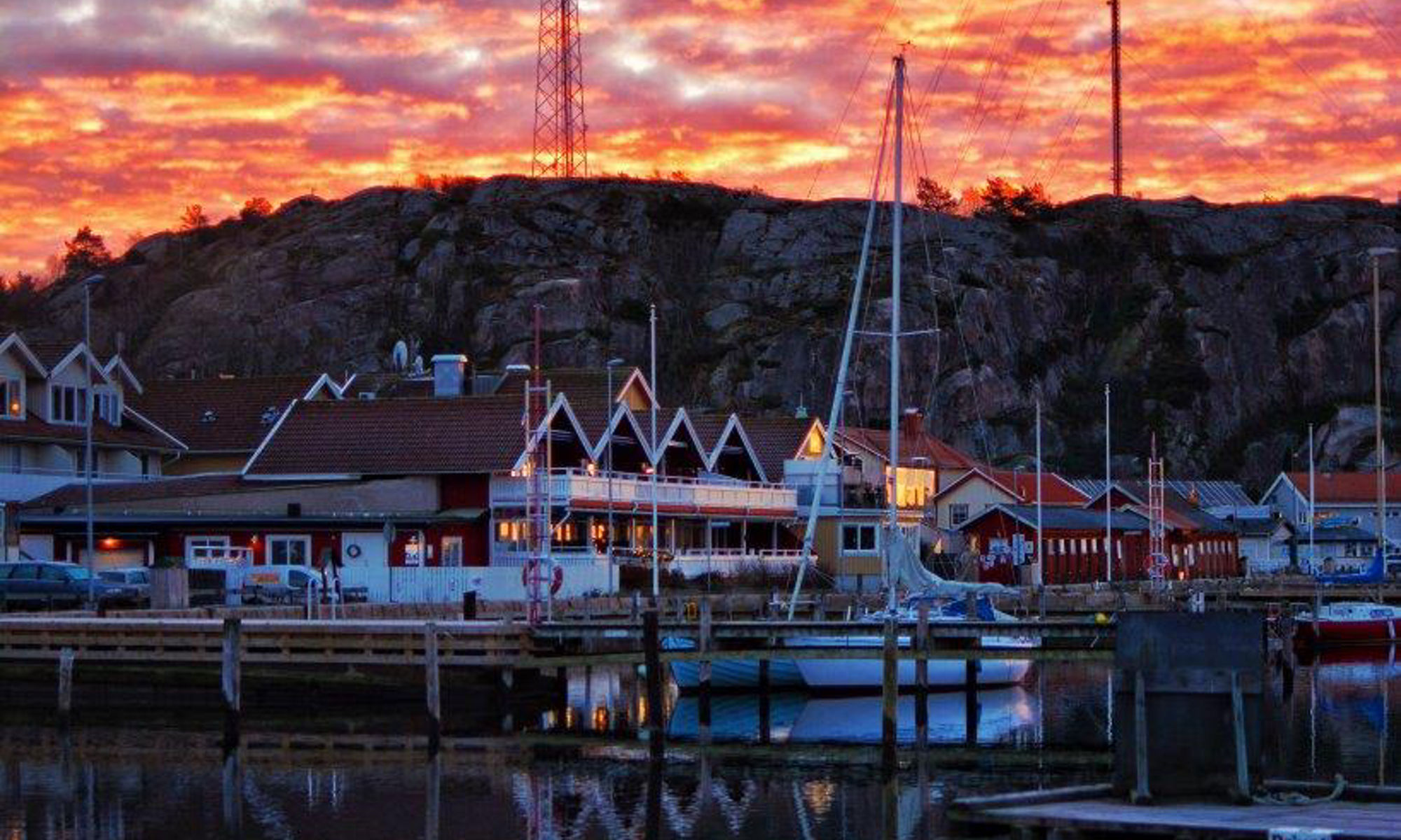 Rosa himmel som speglar av sig i havet i Grebbestad hamn