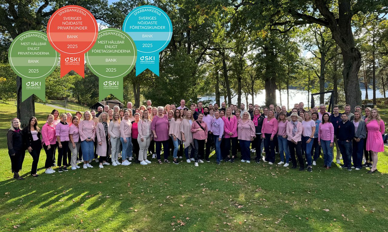 en grupp människor iklädda rosa står på en gräsmatta