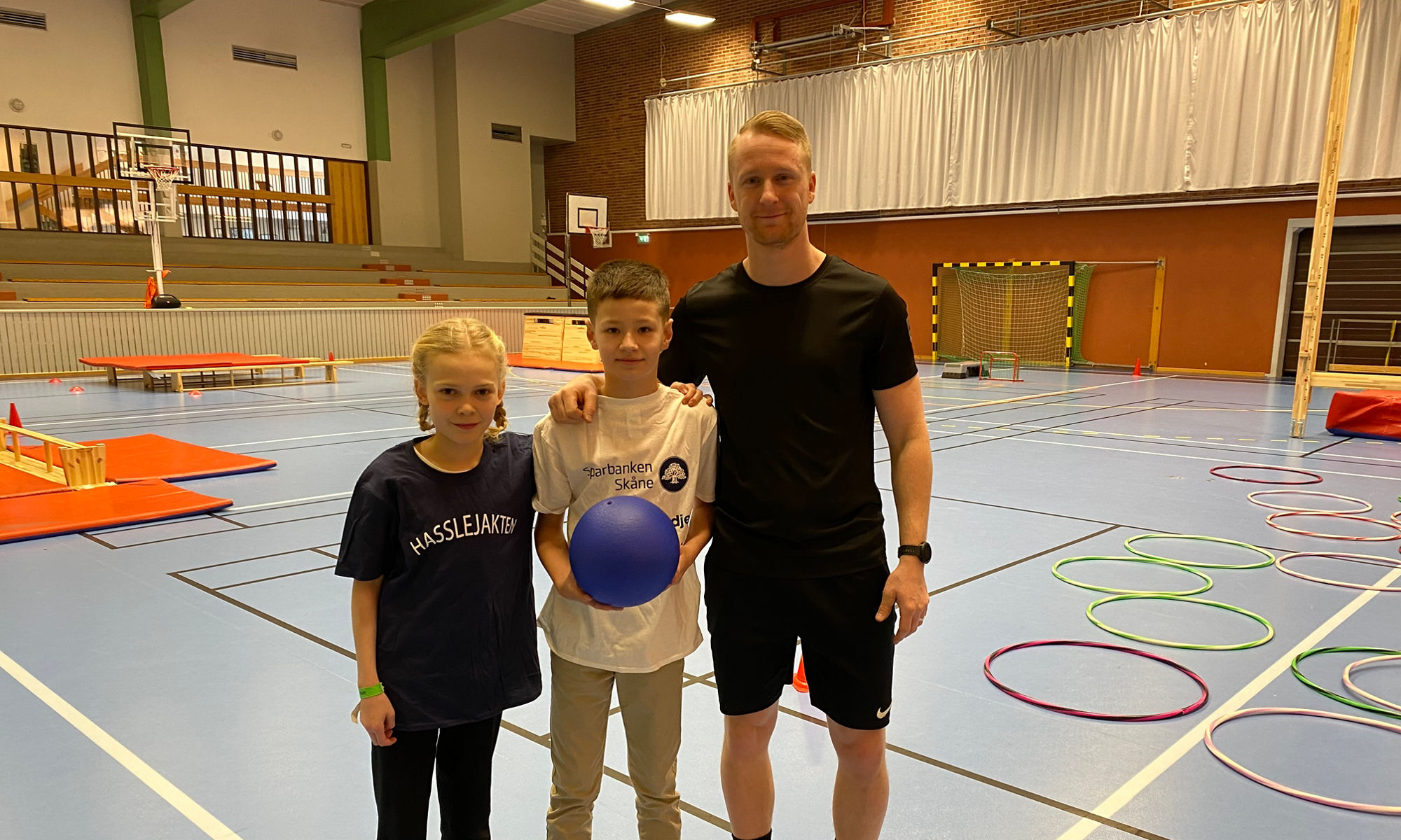 Elever med lärare i en gympahall.