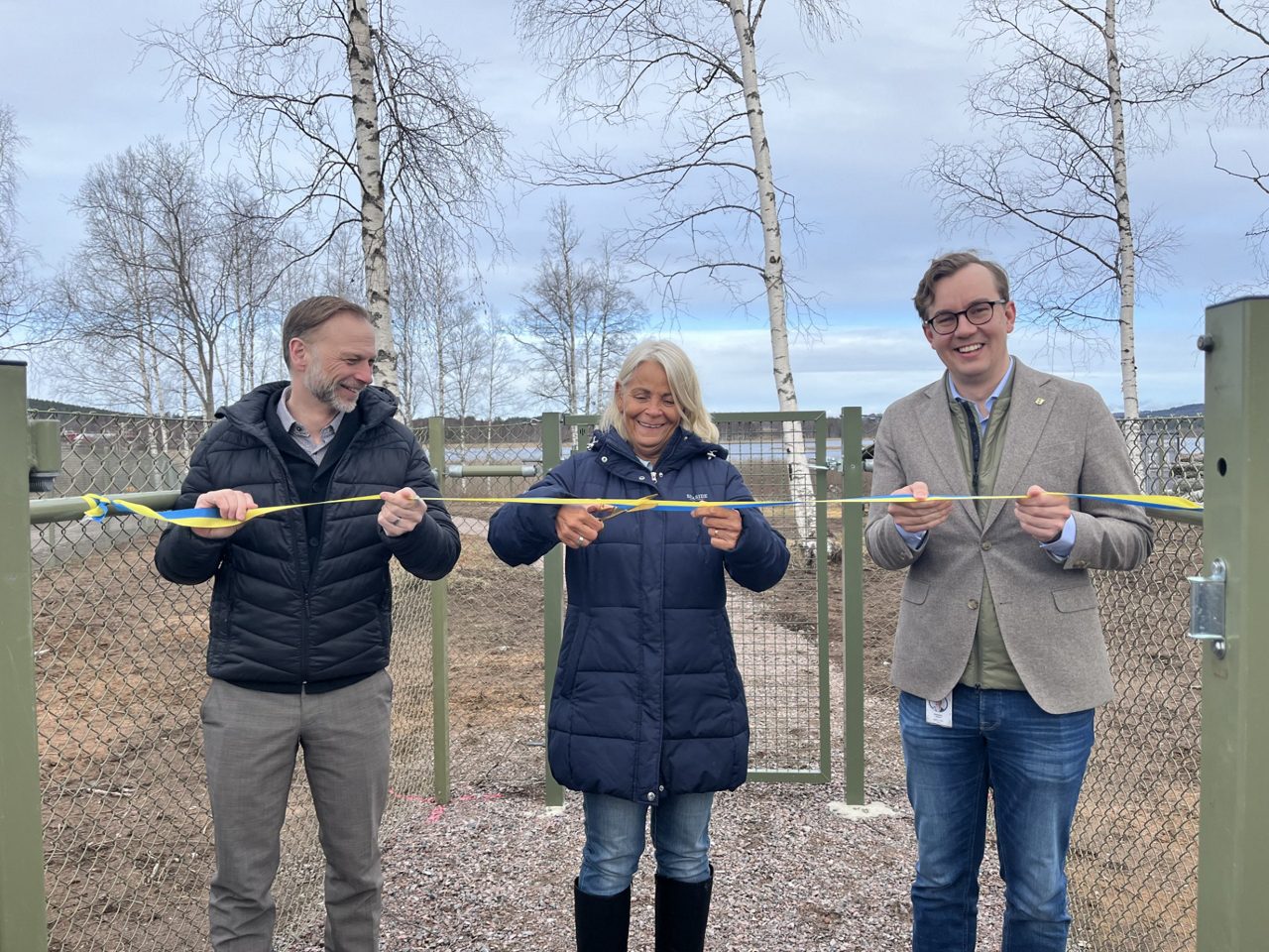 Björn Rinstad, vd Leksands Sparbank, Annika Ulstrup, föreningen Leksands Hundpark, och Sebastian Larsson, Leksands kommun, klipper bandet och inviger hundparken.