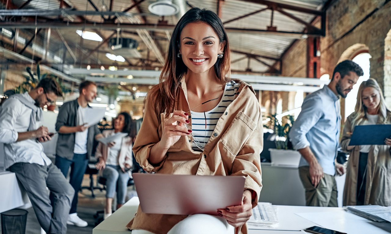 Glad kvinna i kontorsmiljö