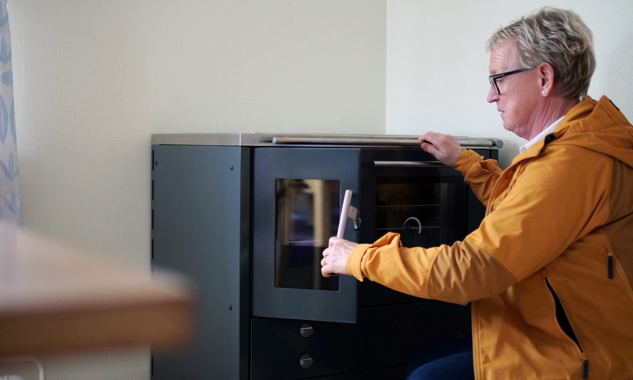 En kvinna öppnar en spis