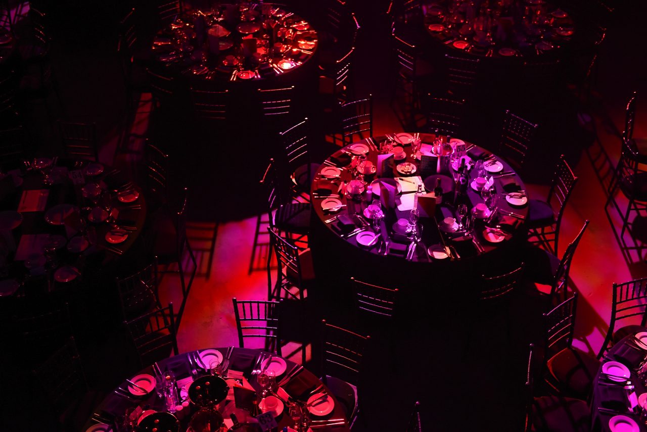 Mörk bild uppifrån med ett stort runt dukat bord