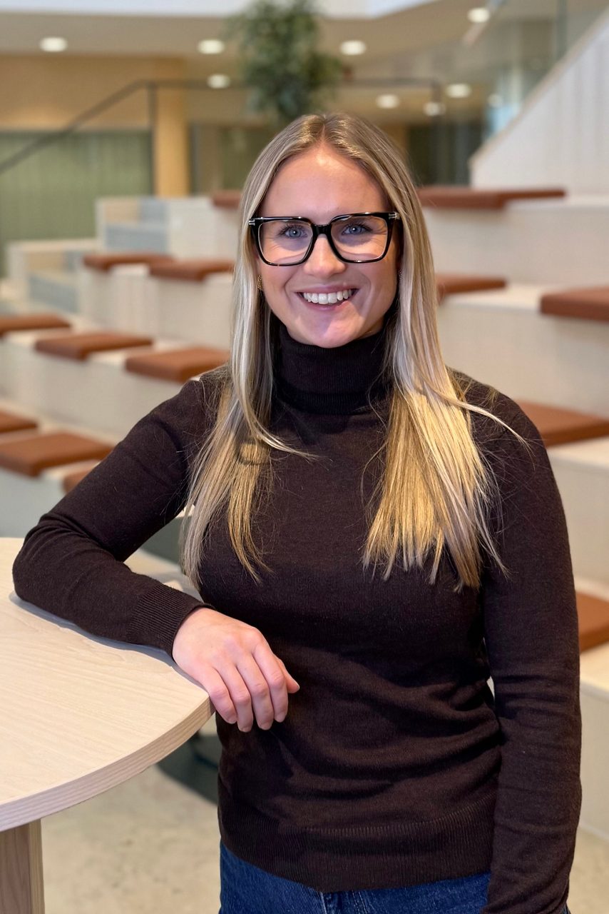 Kvinna tittar in i kameran och ler