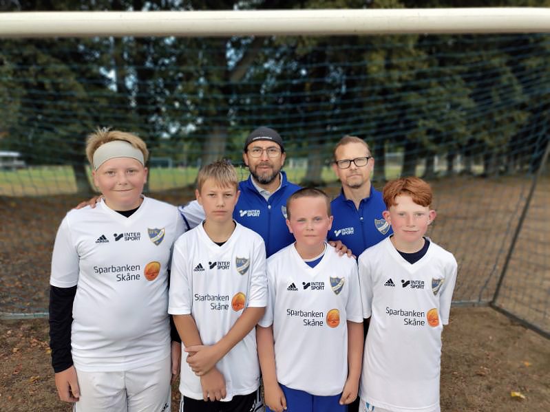 POjkar i ett fotbollslag och två tränare.