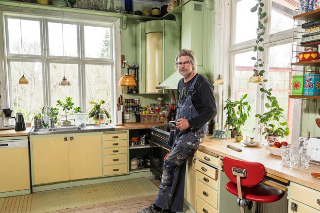 Kunden Lars lutar sig mot en bänk i sitt kök