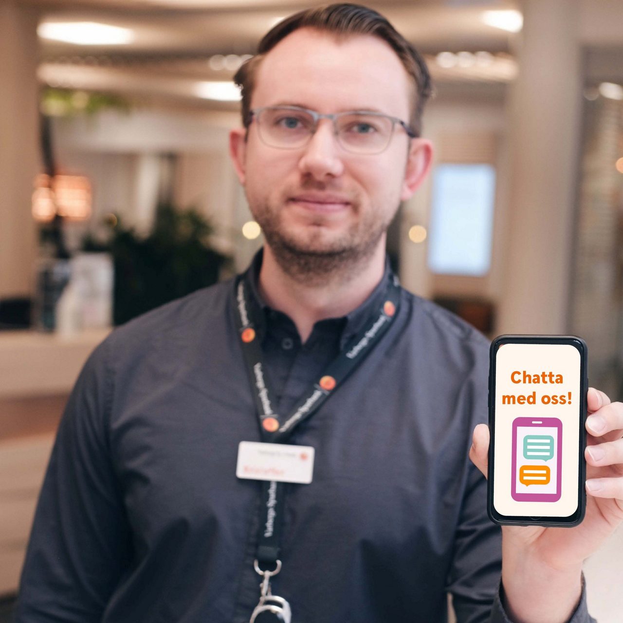 En man med en telefon i hans hand