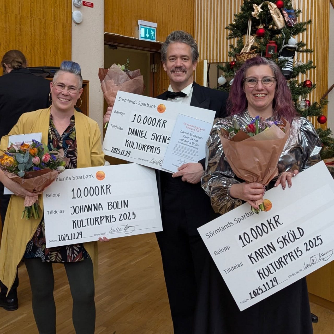 Tre personer som håller i checkar och diplom