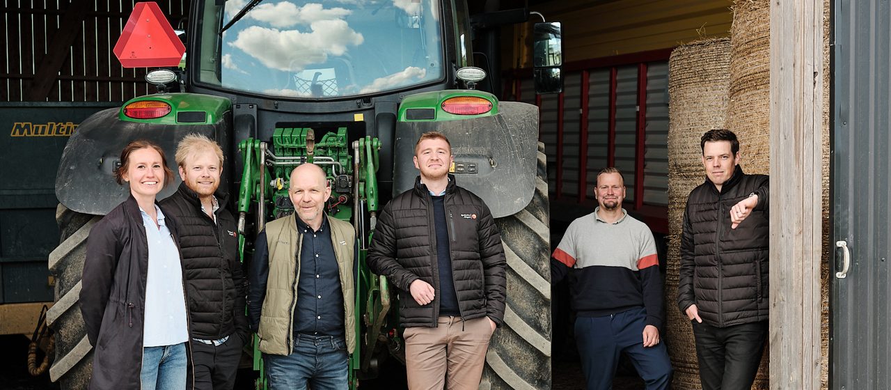 En grupp leende människor på en bondgård